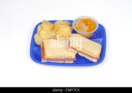 Déjeuner à l'école Le bac concept avec salami et fromage sandwich, chips et coupe de fruits Banque D'Images