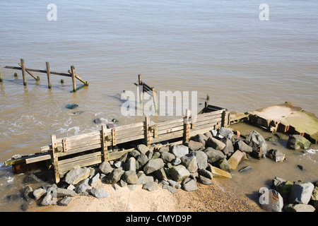 L'érosion côtière rapide Happisburgh Norfolk Angleterre ancienne en bois de défense de la mer et rochers plus récentes Banque D'Images