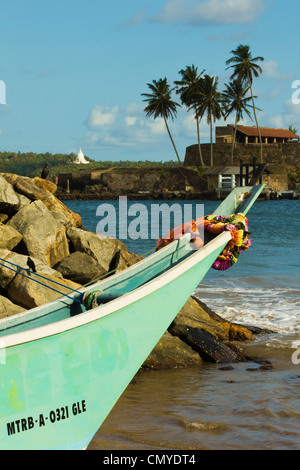 Bateau de pêche en proue le vieux fort harbour avec temple bouddhiste au-delà ; Galle, Province du Sud, Sri Lanka, Asie Banque D'Images