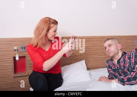 Jeune couple à prendre des photos avec un téléphone mobile Banque D'Images
