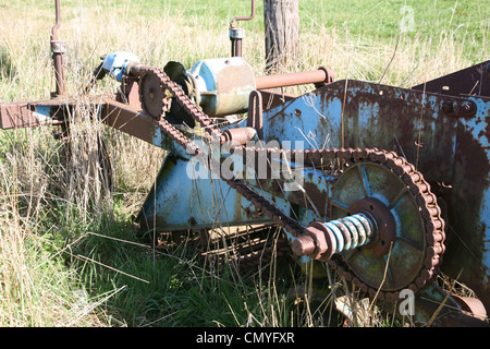 Old farm machinery rouillent dans un champ Banque D'Images