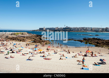 Les gens se baigner de soleil à la plage de la plage de Riazor - Corogne, Galice - Espagne Banque D'Images