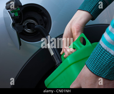 En voiture de l'essence de remplissage jerrycan vert Banque D'Images