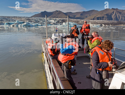 Les photographes en excursion en bateau sur le Jokulsarlon Glacial Lagoon, Breidamerkurjokull, calotte de glace, l'Islande Vatnajokull Banque D'Images