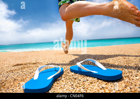 Homme qui court sur la plage avec patins Banque D'Images