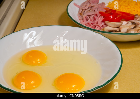 Des œufs frais et des ingrédients prêts pour faire une omelette Banque D'Images