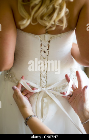 Attacher un arc dans une robe de mariage Banque D'Images