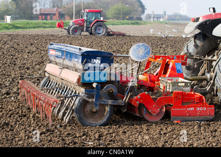 Un bon mètre 4 Ransomes Nordsten semoir grain prêt à être utilisé avec un tracteur de cultiver dans l'arrière-plan sur une ferme de Southport Banque D'Images