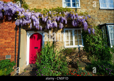 Chalets Ville de glycine poussent sur eux. High Street, Buckingham Bucks Banque D'Images