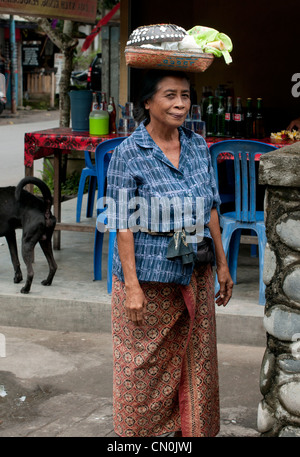 UBUD - 5 Avril 2011 : old woman carrie shoppings sur sa tête le 5 avril 2011 sur rue à Ubud Bali, Indonésie Banque D'Images