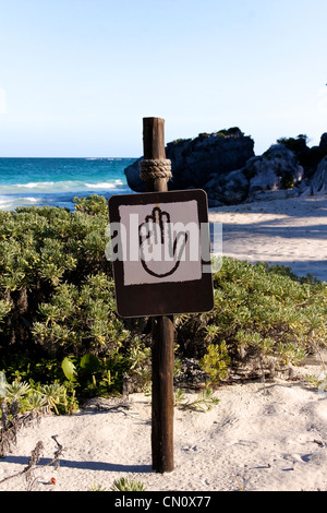 Brown et montrant un signe tan pictogramme main à une belle plage des Caraïbes (format portrait) Banque D'Images