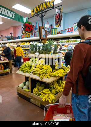 Jeune homme à la banane et au stand de fruits à Trader Joe's, 22 St., Philadelphie, USA Banque D'Images