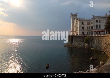 Château de Miramare au coucher du soleil à Trieste en Italie, un château blanc surplombant la mer Banque D'Images