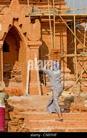 Des femmes portant des briques sur la tête, Bagan, Myanmar Banque D'Images