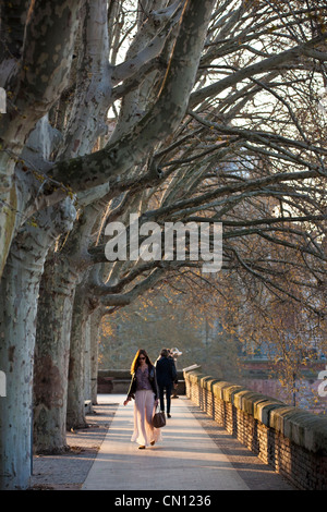 Une jeune femme marche le long d'un boulevard bordé d'arbres, Lucien Lombard, Toulouse, France. Banque D'Images