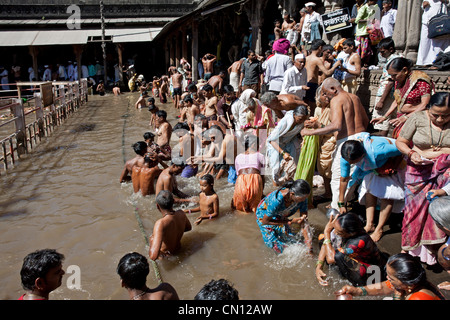 Pèlerins hindous se baigner dans l'eau sacrée réservoir d'Kushavarta (la source de la rivière Godavari). Trimbakeshwar. L'Inde Banque D'Images