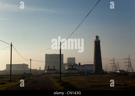 L'Angleterre, Kent, Romney Marsh, Dungeness, silhouette d'énergie nucléaire et le phare. Banque D'Images