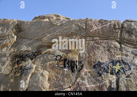 Un morceau de graffitis sur les rochers sur la côte de la Costa Brava Banque D'Images