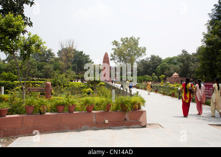 Les gens à l'intérieur de Jallianwala Bagh sur un chemin de ciment et de plantes en pot, un monument situé au massacre de centaines de personnes en 1919 Banque D'Images