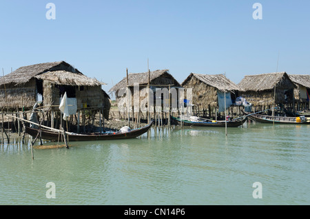 Huttes de bambou et bateaux le long d'une voie navigable. Delta de l'Irrawaddy. Le Myanmar. Banque D'Images