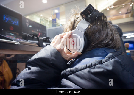 Un client dans un magasin Best Buy à New York à l'écoute sur casque Beats by Dr. Dre Banque D'Images