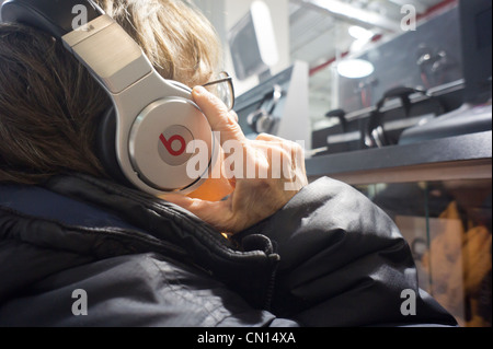 Un client dans un magasin Best Buy à New York à l'écoute sur casque Beats by Dr. Dre Banque D'Images