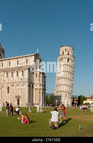 Des touristes posent pour des photos faisant semblant de retenir la Tour de Pise sur la Piazza dei Miracoli, Italie Banque D'Images