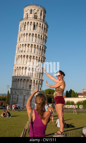 Des touristes posent pour des photos faisant semblant de retenir la Tour de Pise sur la Piazza dei Miracoli, Italie Banque D'Images