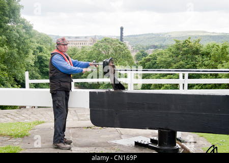 Le Leeds et Liverpool Canal, Bingley, West Yorkshire, en Grande-Bretagne au lieu de cinq écluses avec un homme d'ouvrir les serrures Banque D'Images