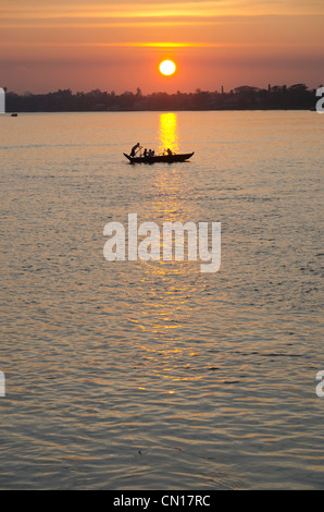 Bateau à rames traditionnelles sur la rivière au coucher du soleil. Pathein. Delta de l'Irrawaddy. Myamar. Banque D'Images