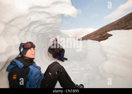 Les alpinistes à l'abri dans un trou à neige dans les montagnes de Cairngorm, Ecosse, Royaume-Uni. Banque D'Images