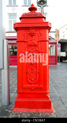 Et historique fleuri rouge fontaine à Brugge street Banque D'Images