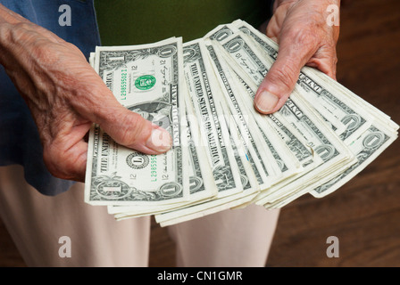 Older Woman's Hands Holding Dollar Bills Banque D'Images