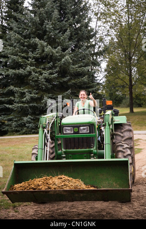 Sur femme Thumbs-Up donnant Bulldozer Banque D'Images