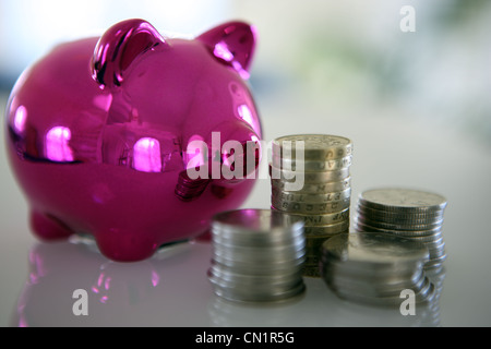 Pink piggy bank et des tas d'argent Banque D'Images