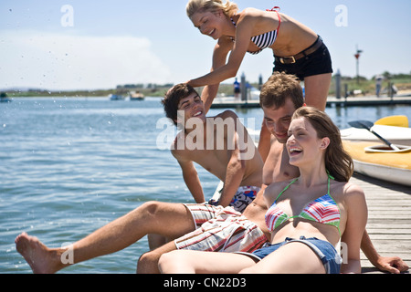 Deux jeunes couples s'amusant sur le bord de la jetée Banque D'Images
