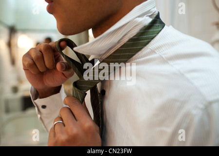 Man putting on tie Banque D'Images