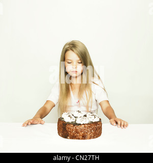 Photo de l'adorable petite fille avec gâteau sur fond blanc Banque D'Images