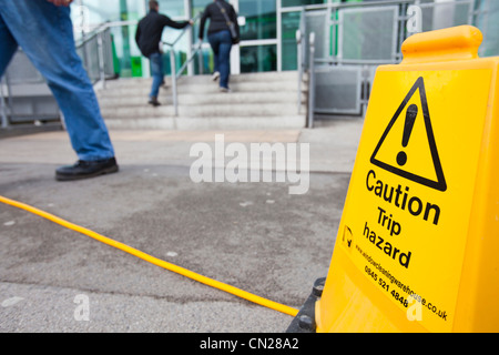 Un trébuchement signe par un tuyau flexible à l'extérieur de l'Asda Keighley, West Yorkshire, Royaume-Uni. Banque D'Images