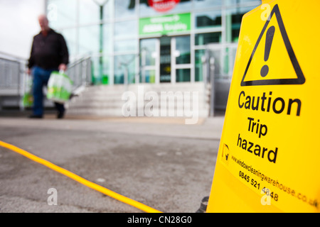 Un trébuchement signe par un tuyau flexible à l'extérieur de l'Asda Keighley, West Yorkshire, Royaume-Uni. Banque D'Images