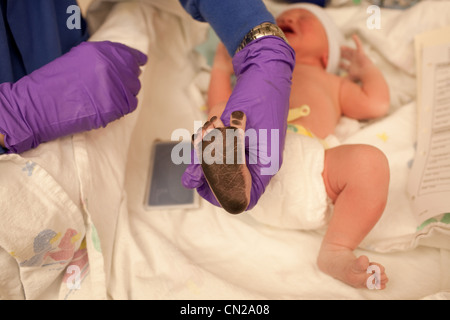 Bébé nouveau-né garçon avec de l'encre sur la plante des pieds Banque D'Images