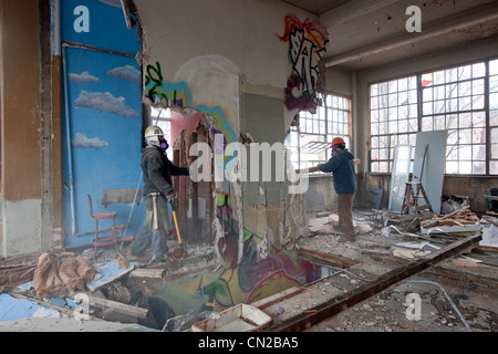 L'éviscération des travailleurs du bâtiment industriel abandonné acheté en vente aux enchères bankrupcty. Banque D'Images