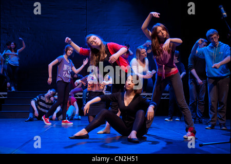 Un groupe de garçons et filles, les adolescents chantant et dansant dans un théâtre musical amateur performance production dans un théâtre. UK Banque D'Images