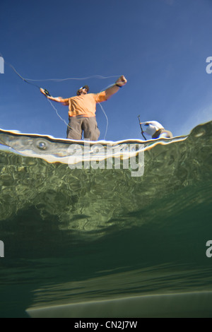Plus de et sous-Vue de deux hommes La pêche de mouche en bateau près de Shipwreck, Florida Keys, USA Banque D'Images