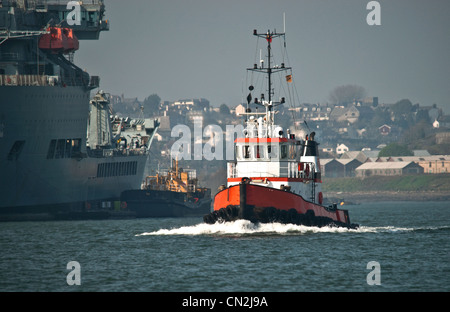 Un petit bateau de travail / remorqueur Bateau à passé un navire auxiliaire de la Flotte royale dans la Rivière Tamar Banque D'Images