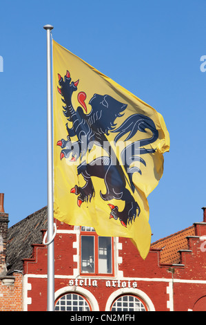 Le drapeau de la Flandre de haut vol sur la place du marché à Bruges, Belgique Banque D'Images