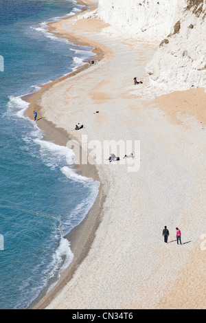 Visiteurs promenade le long de l'estran à Durdle Door Bay sur la côte jurassique du Dorset Banque D'Images