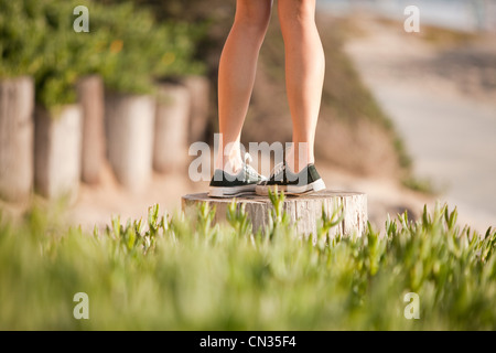 Young woman walking on wooden post Banque D'Images
