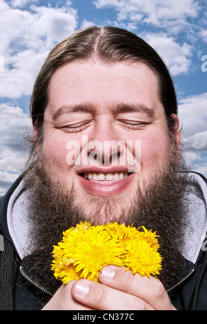 Heureux homme barbu avec des fleurs jaunes Banque D'Images