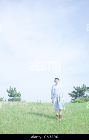 Young woman standing in field Banque D'Images